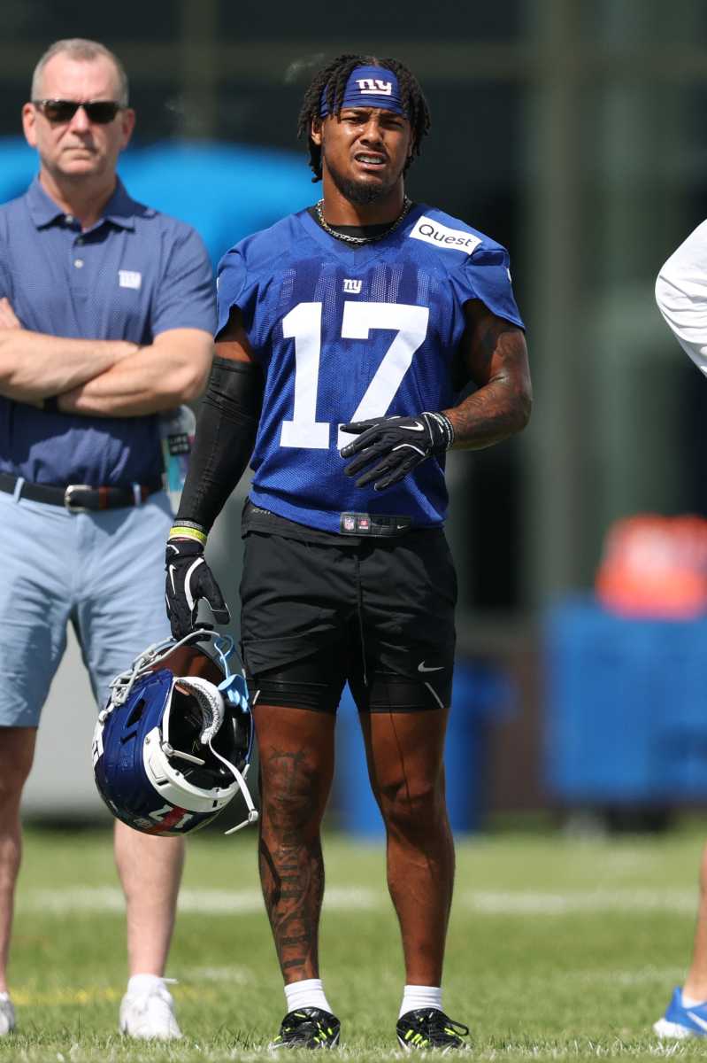 Giants training camp: Five things to know as Big Blue suits up for first day of pads 2 giants player in blue uniform and shorts while holding helmet at training camp