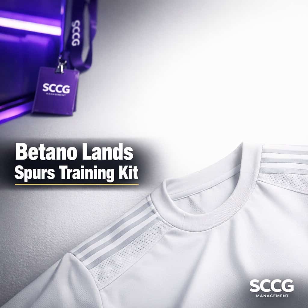 Close-up of a Tottenham training jersey under bright studio light, clean white fabric filling the lower-right with open luminous space above.