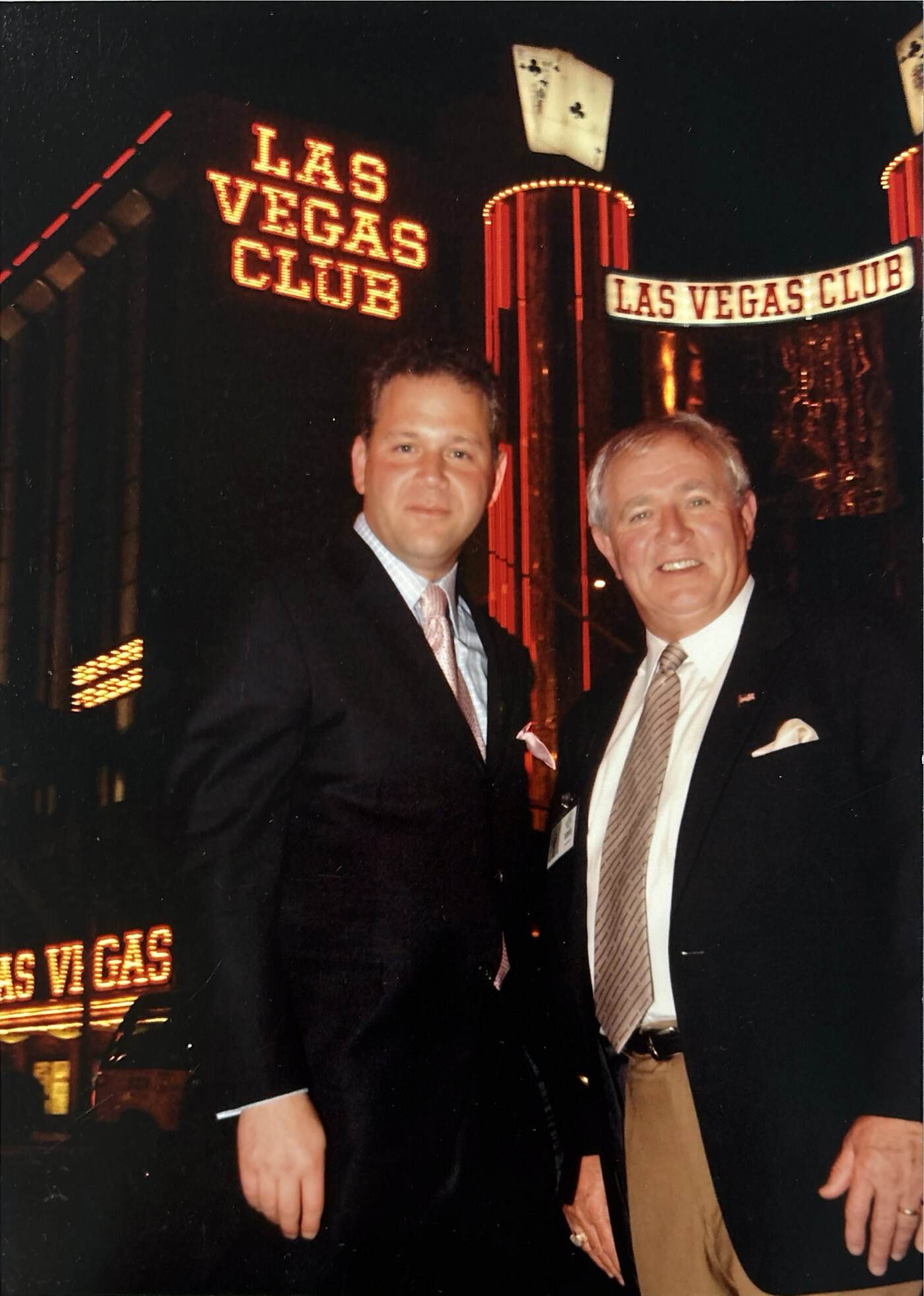 Dave Barrick and Stephen Crystal standing side by side at night beneath the neon Las Vegas Club sign.