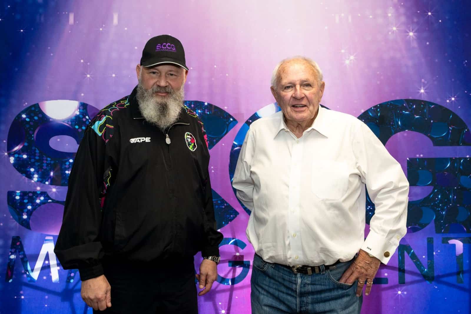 Stephen Crystal and D.W. "Dave" Barrick in front of the SCCG Management backdrop